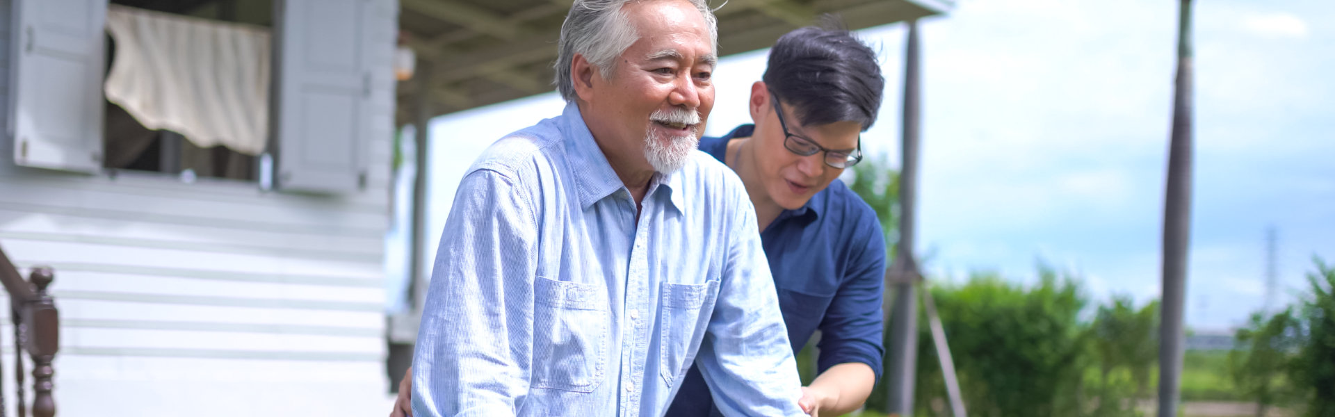 Man assisting elderly to walk